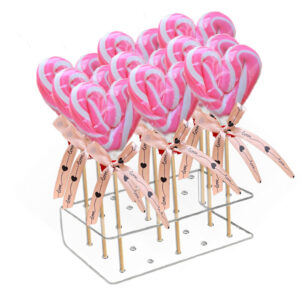 Personalizovane candy cane lizalice sa crvenim i belim prugama na rođendanskom slatkom stolu.